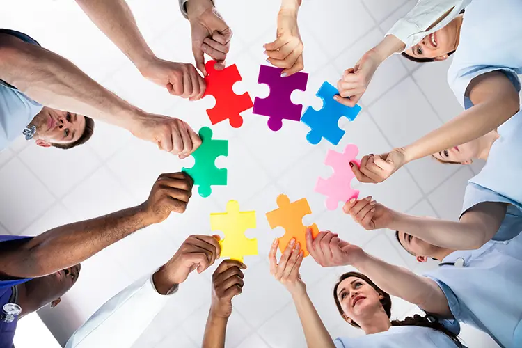 Medical professionals holding jigsaw pieces