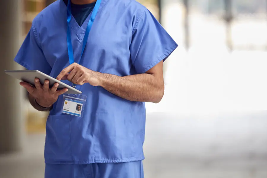 Medical worker in scrubs with digital tablet