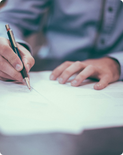 Person writing on paper with pen