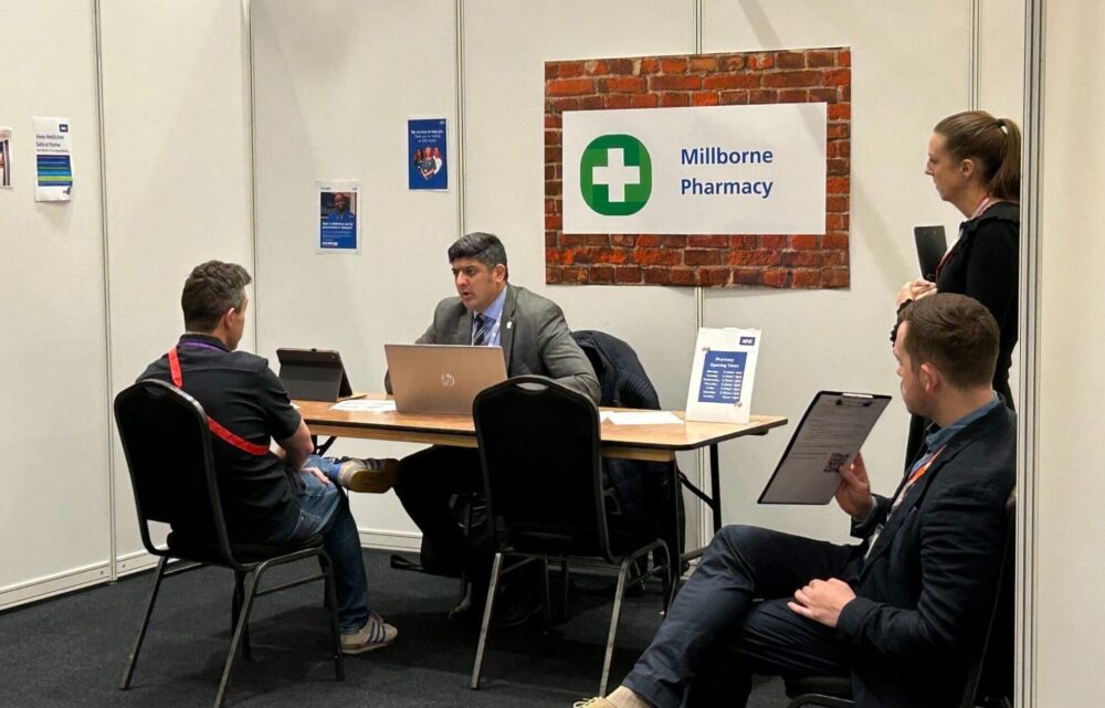 Image of GP at Milborne pharmacy talking to resident with two observers